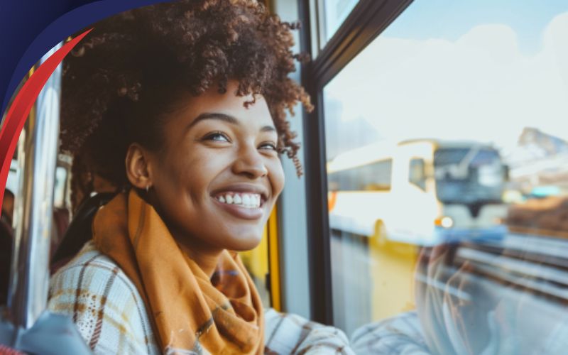 person smiling and looking out of bus window, sustainable travel, June 2024, NZ